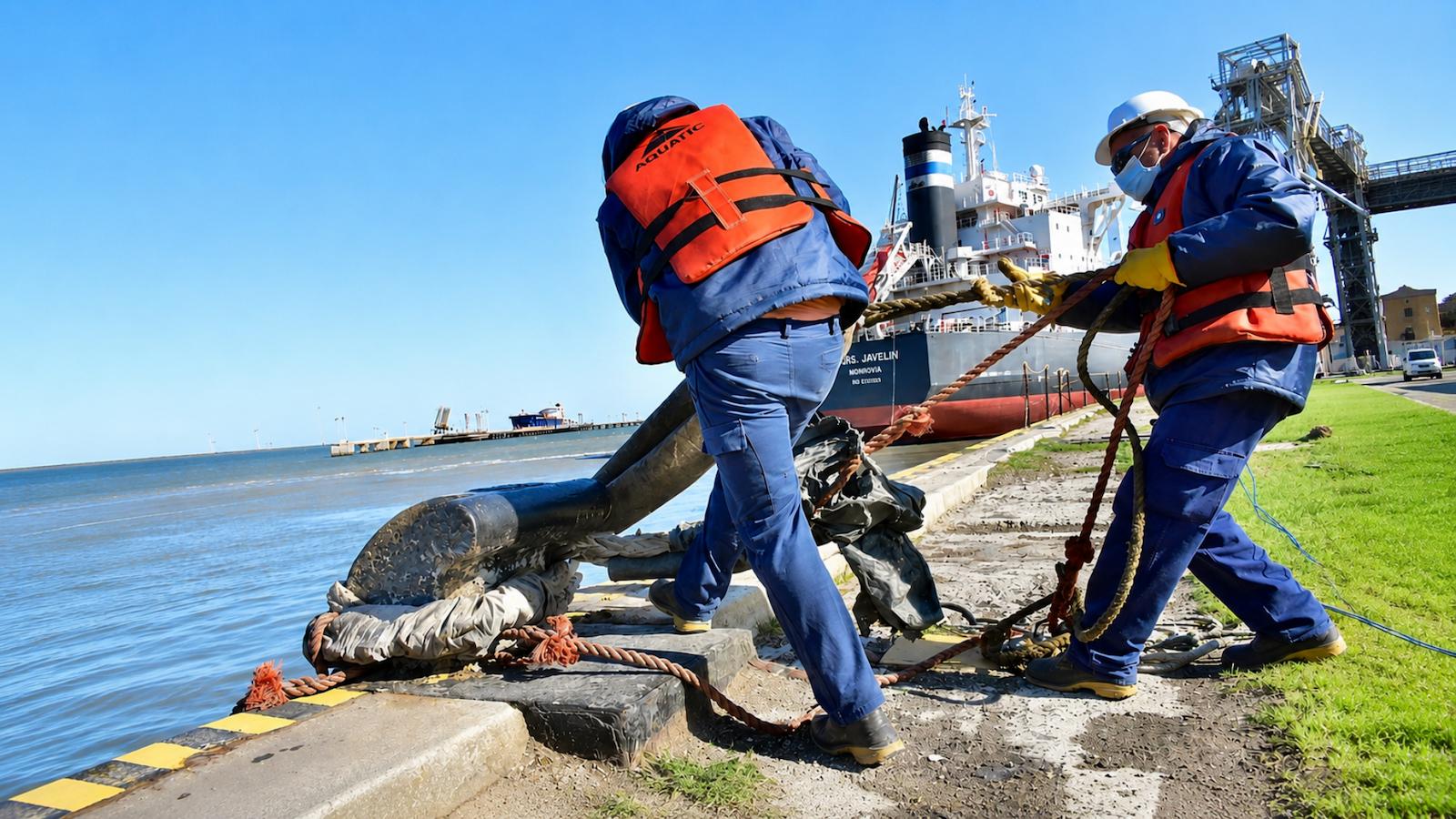Personal realizando una maniobra de amarre de buque en una operación portuaria de Lanchas del Sur